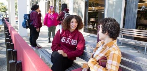 Students sitting and standing in front of Adams library